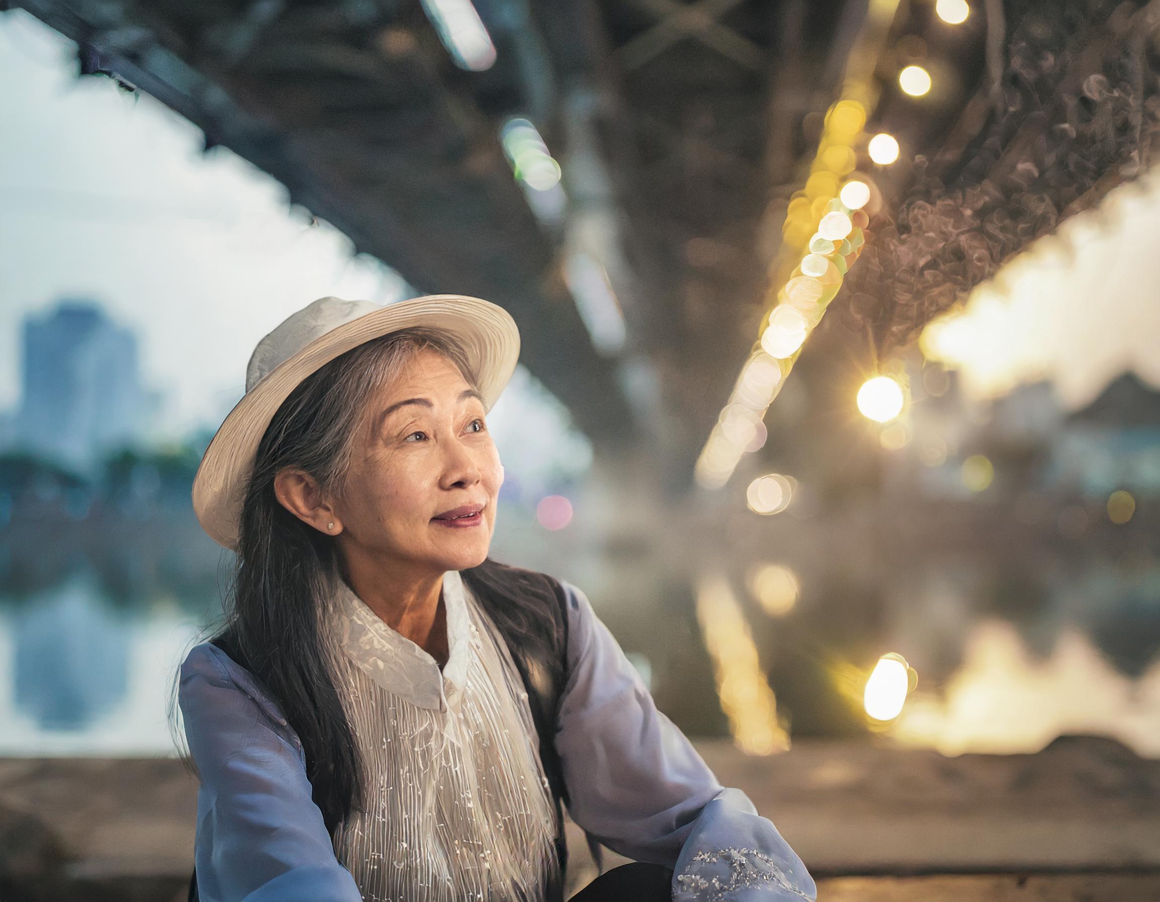 Firefly homeless old vietnamese lady, sitting under Long Biên Bridge in Hanoi. grimy face and dirty